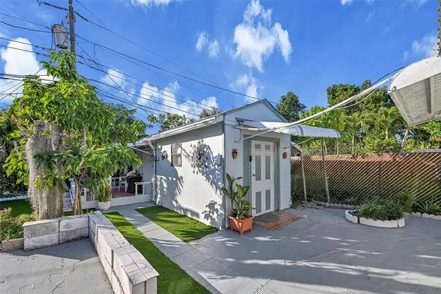 a view of a patio with table and chairs potted plants and palm trees