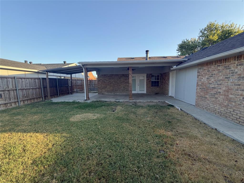 8601 Woodside Road Rowlett, TX 75088 - Photo 12 of 22 Brick exterior with covered patio, concrete walkway, and private fenced yard