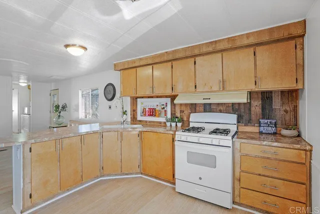 a kitchen with cabinets appliances a sink and a window