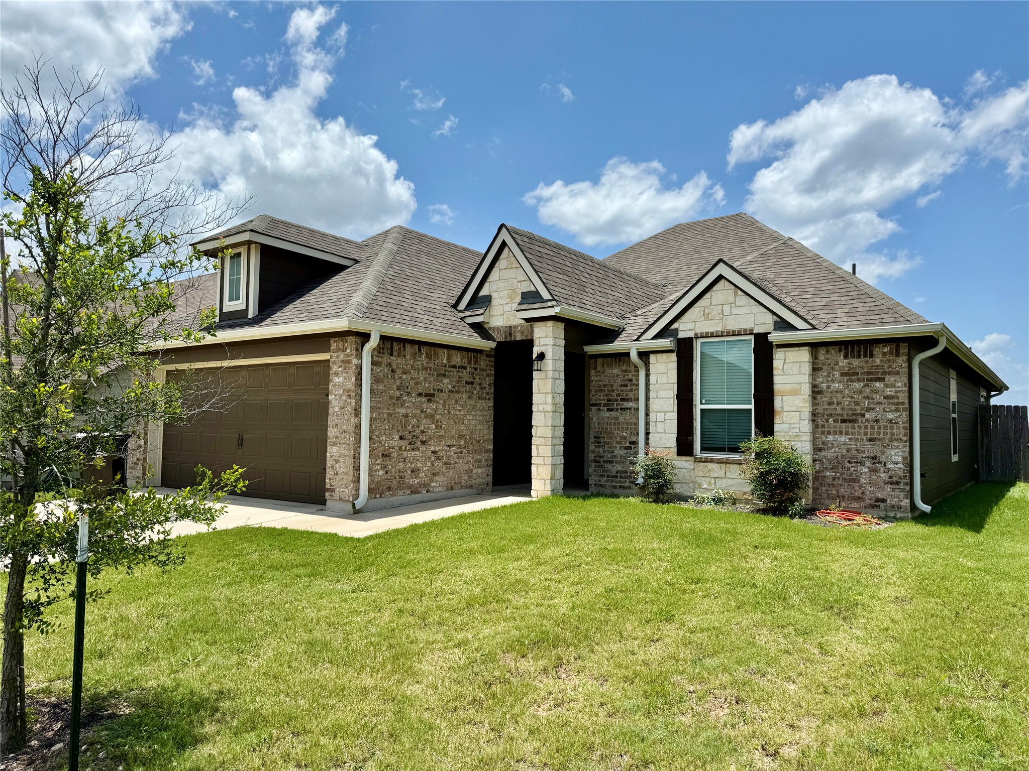 808 Fallbrook Drive Temple, TX 76502 - Photo 2 of 36 View of front of property featuring a front yard, roof with shingles, stone siding, and brick siding