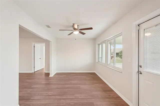 a view of a big room with wooden floor and ceiling fan