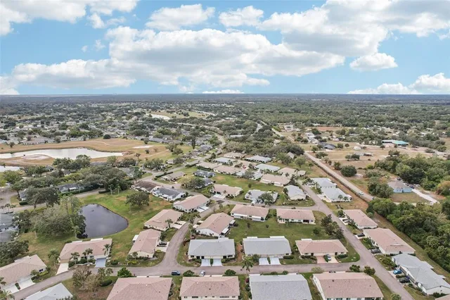 an aerial view of a residential apartment building with a yard and flowers