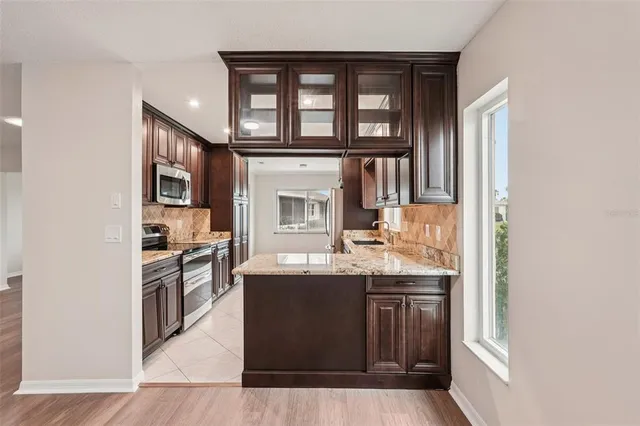 a kitchen with granite countertop a sink stove and cabinets