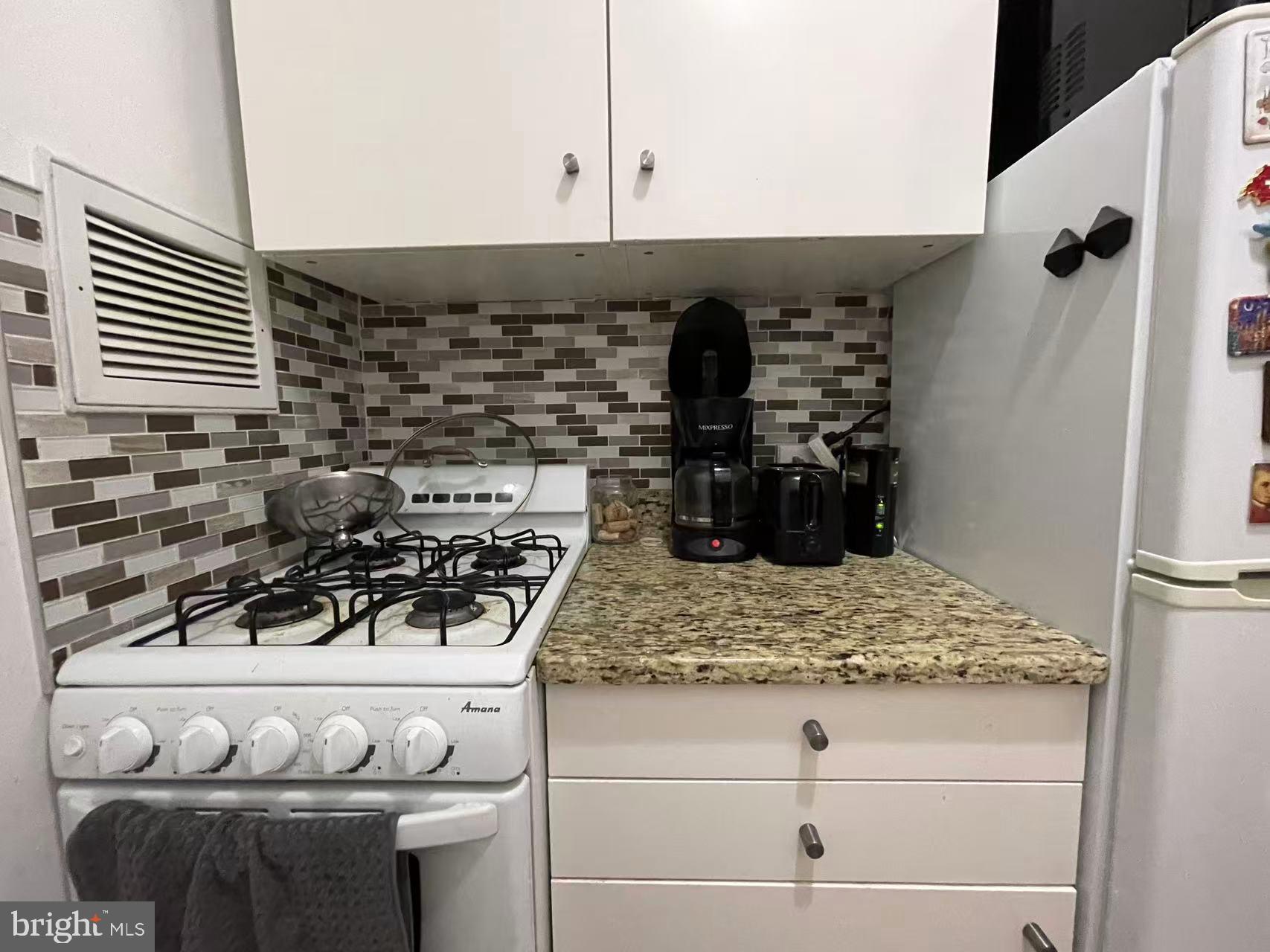 210 Locust Street, Unit 22EW Philadelphia, PA 19106 - Photo 16 of 21 a kitchen with a stove and white cabinets