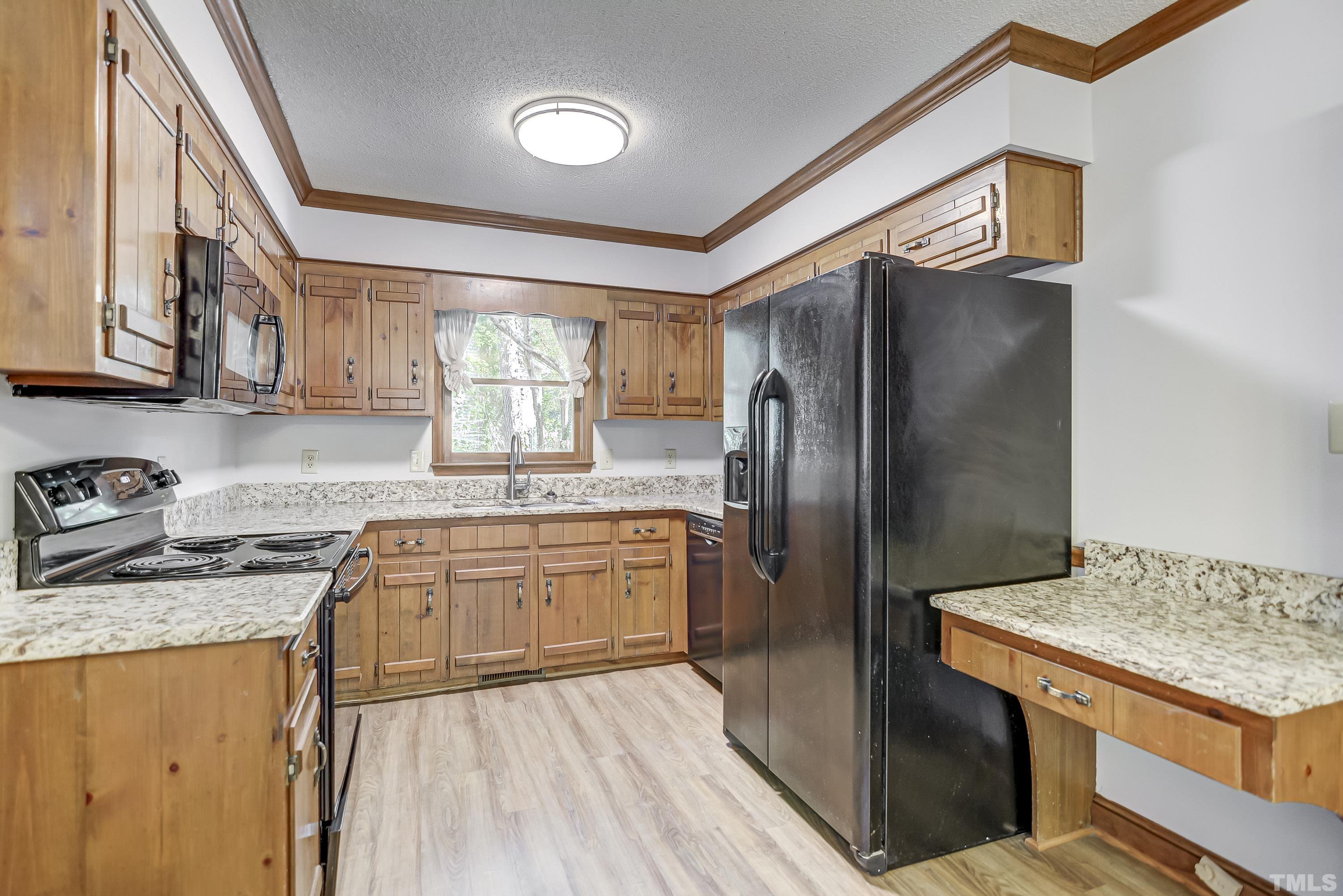 7400 Old Hundred Road Raleigh, NC 27613 - Photo 6 of 17 a kitchen with stainless steel appliances granite countertop a refrigerator a sink dishwasher a stove and white countertops with wooden floor