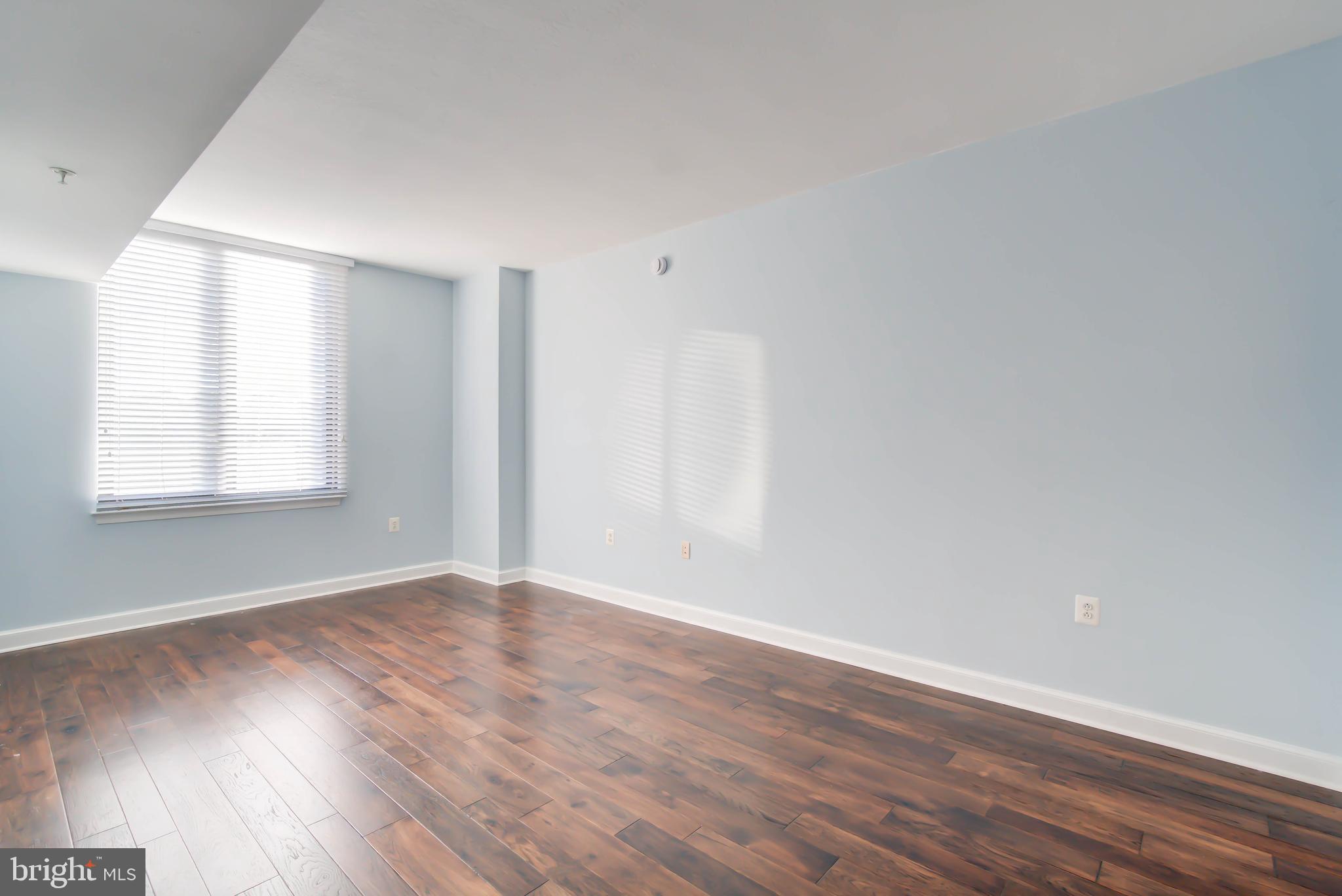 2451 Midtown Avenue, Unit 1327 Alexandria, VA 22303 - Photo 14 of 32 an empty room with wooden floor and windows