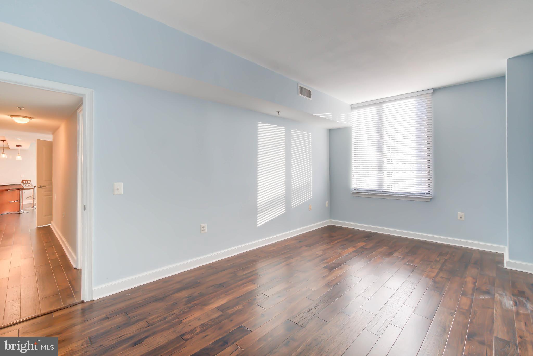 2451 Midtown Avenue, Unit 1327 Alexandria, VA 22303 - Photo 15 of 32 a view of an empty room with wooden floor and a window