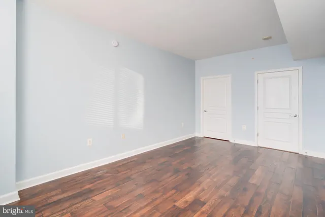 a view of an empty room with wooden floor