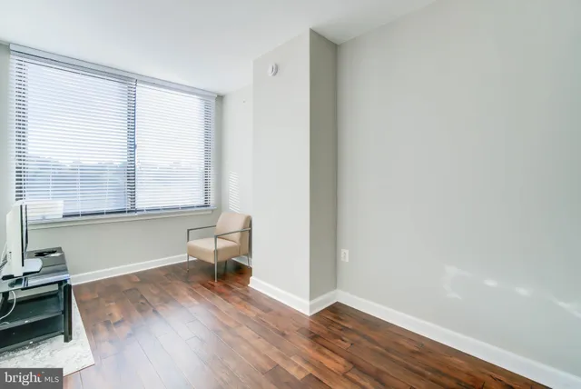 a view of a room with wooden floor and a window