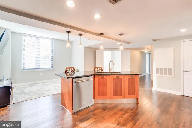 a view of a kitchen with stainless steel appliances wooden floor and a window