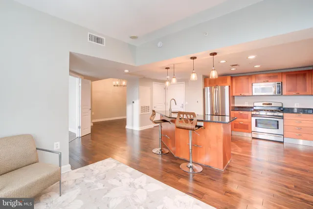 a view of a living room kitchen with furniture and wooden floor