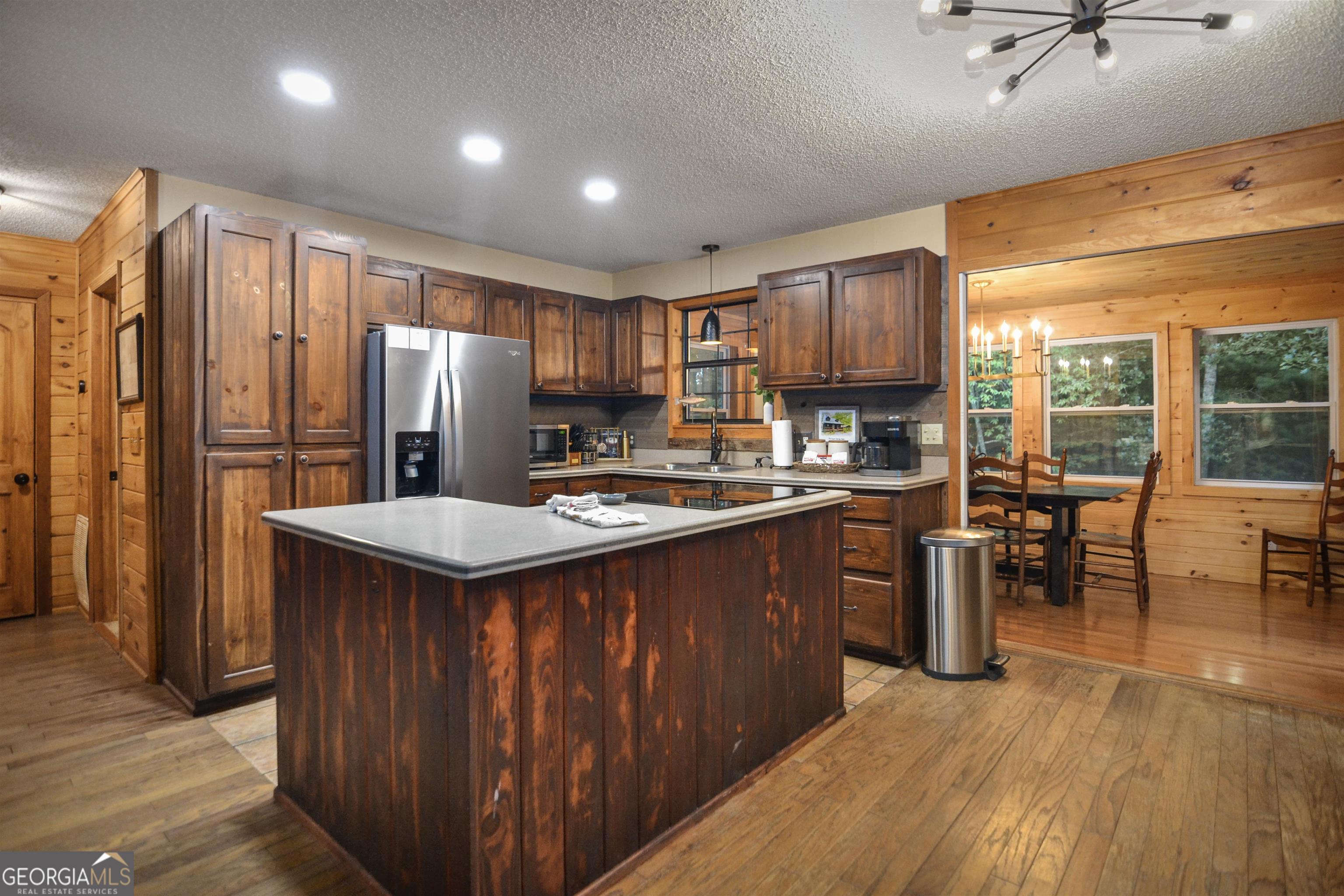 161 Old Dial Road Morganton, GA 30560 - Photo 16 of 40 a kitchen with stainless steel appliances granite countertop a refrigerator a sink dishwasher a stove and a dining table with wooden floor