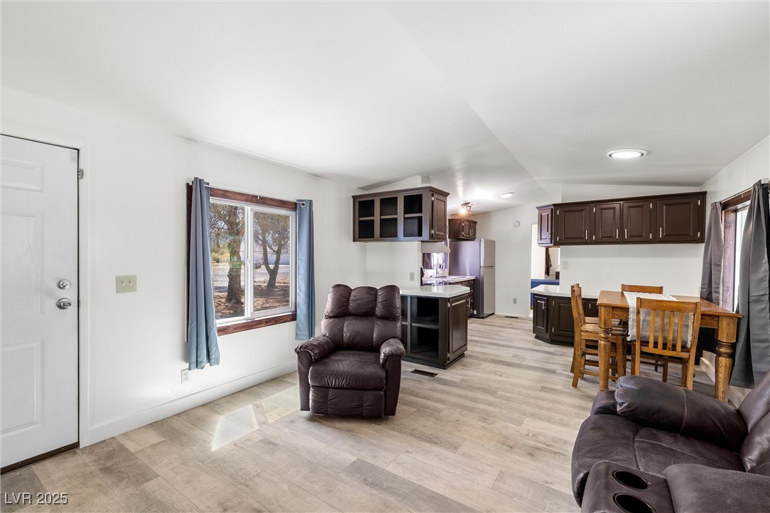 Living room featuring light wood-style floors and vaulted ceiling