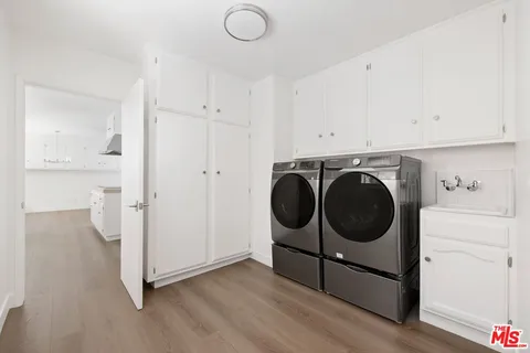 a utility room with wooden floor and cabinets
