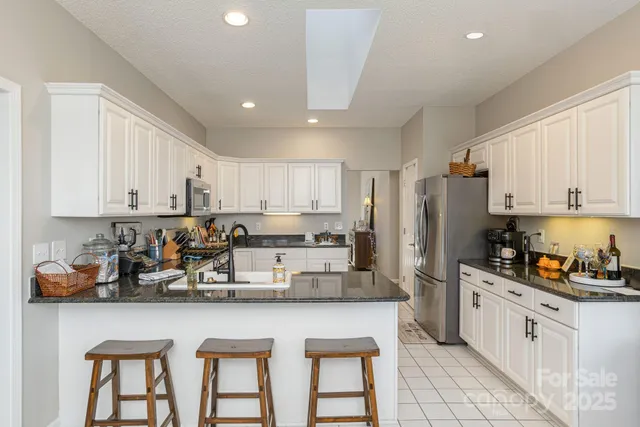 a kitchen with refrigerator a stove a sink and cabinets