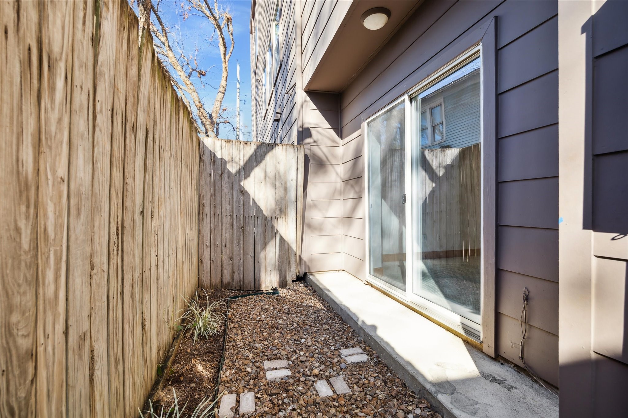 94 Drew Street, Unit C Houston, TX 77006 - Photo 7 of 29 Secondary room opens to a private outdoor sitting area, creating a seamless indoor-outdoor extension ideal for relaxing, or quiet morning coffee.