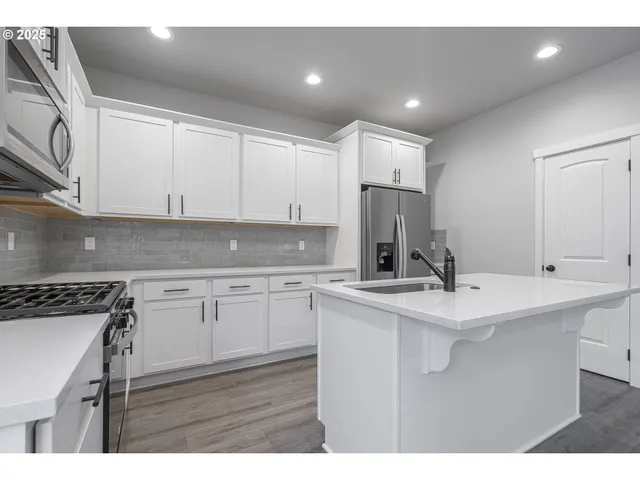 a kitchen with kitchen island sink stove and cabinets