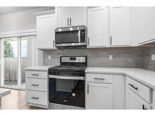 a kitchen with white cabinets stainless steel appliances and sink
