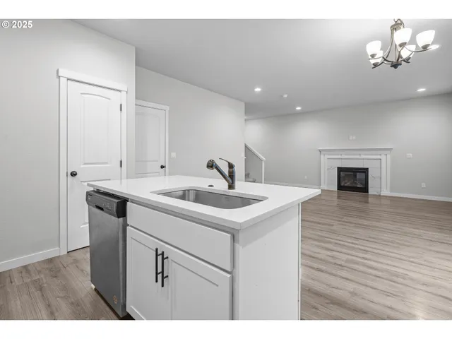 a kitchen with a sink cabinets and wooden floor