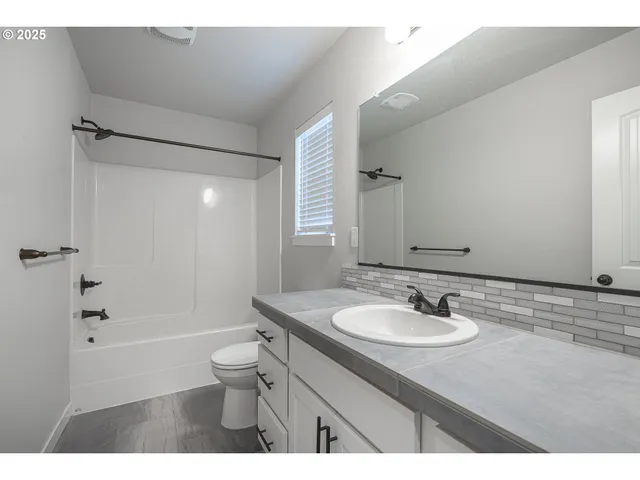 a bathroom with a sink a toilet a mirror and shower