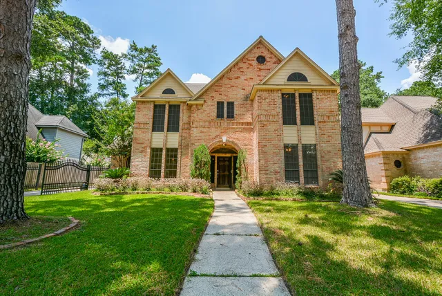 a front view of a house with a yard and trees