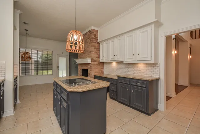 a kitchen with granite countertop a refrigerator stove and cabinets