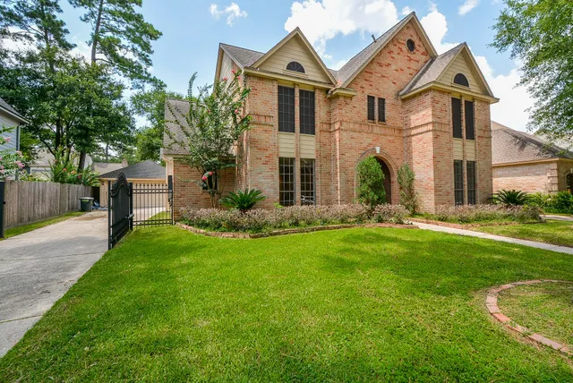 a front view of a house with a yard and a tree