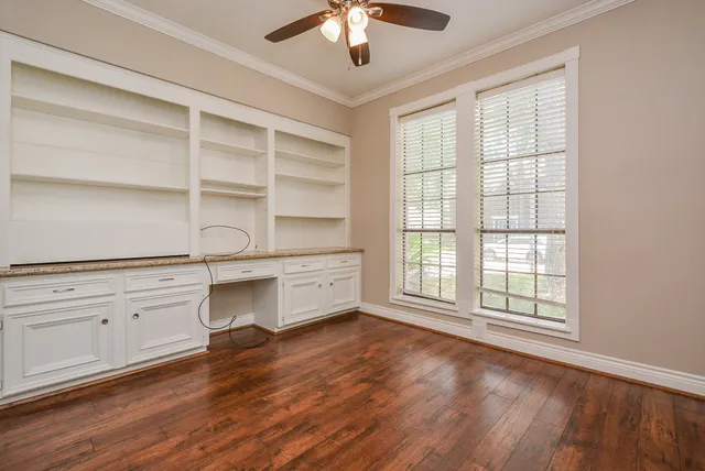 a view of staircase with lots of frames on wall and wooden floor
