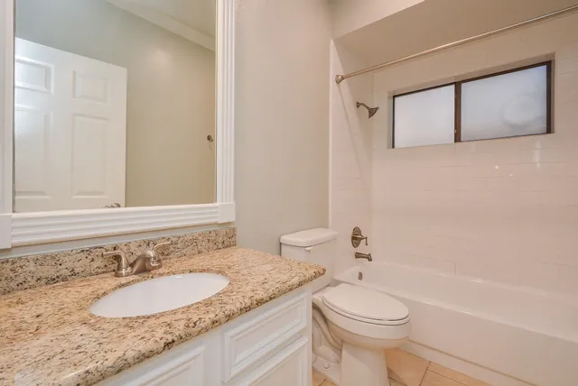 an empty room with closet and a ceiling fan