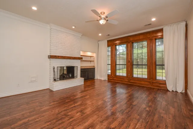 a view of empty room with wooden floor and fireplace