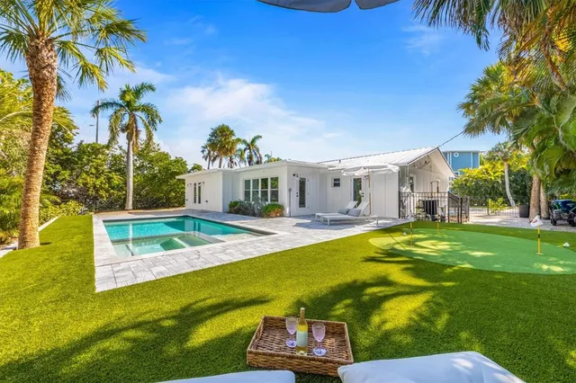 a view of an house with swimming pool lawn chairs and a fire pit
