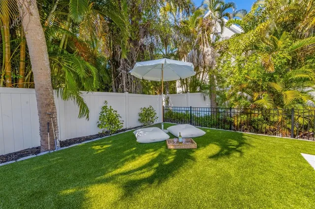 a view of a backyard with table and chairs under an umbrella