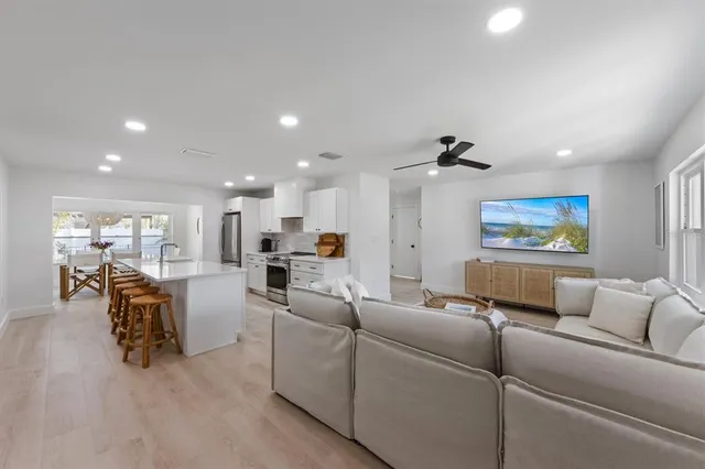 a living room with furniture and a view of kitchen