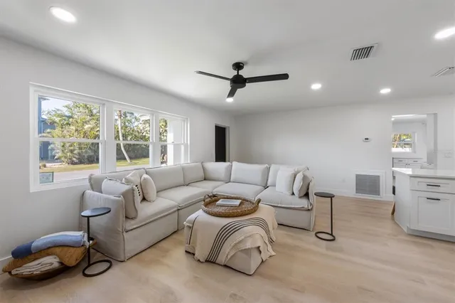 a living room with furniture a ceiling fan and a window