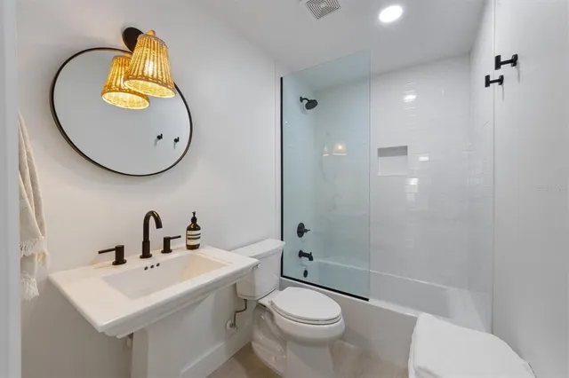 a bathroom with a sink a toilet and a mirror