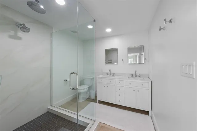 a spacious bathroom with a shower sink and mirror