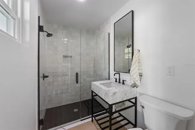 a bathroom with a sink a toilet and shower