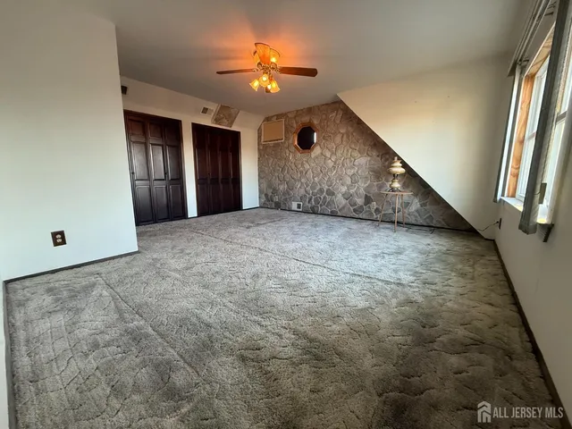 en empty room with windows and ceiling fan