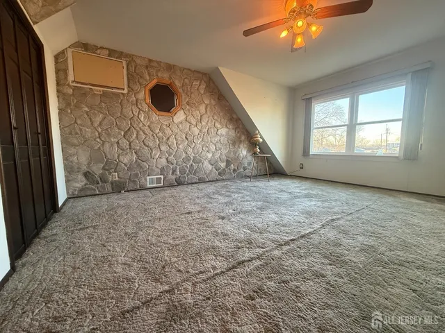an empty room with a window and a ceiling fan