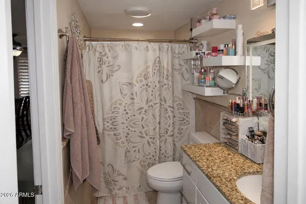 a bathroom with a toilet sink and shower curtain