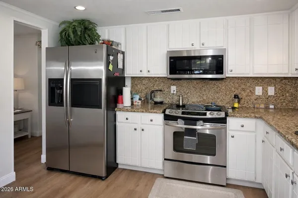 a kitchen with stainless steel appliances and white cabinets