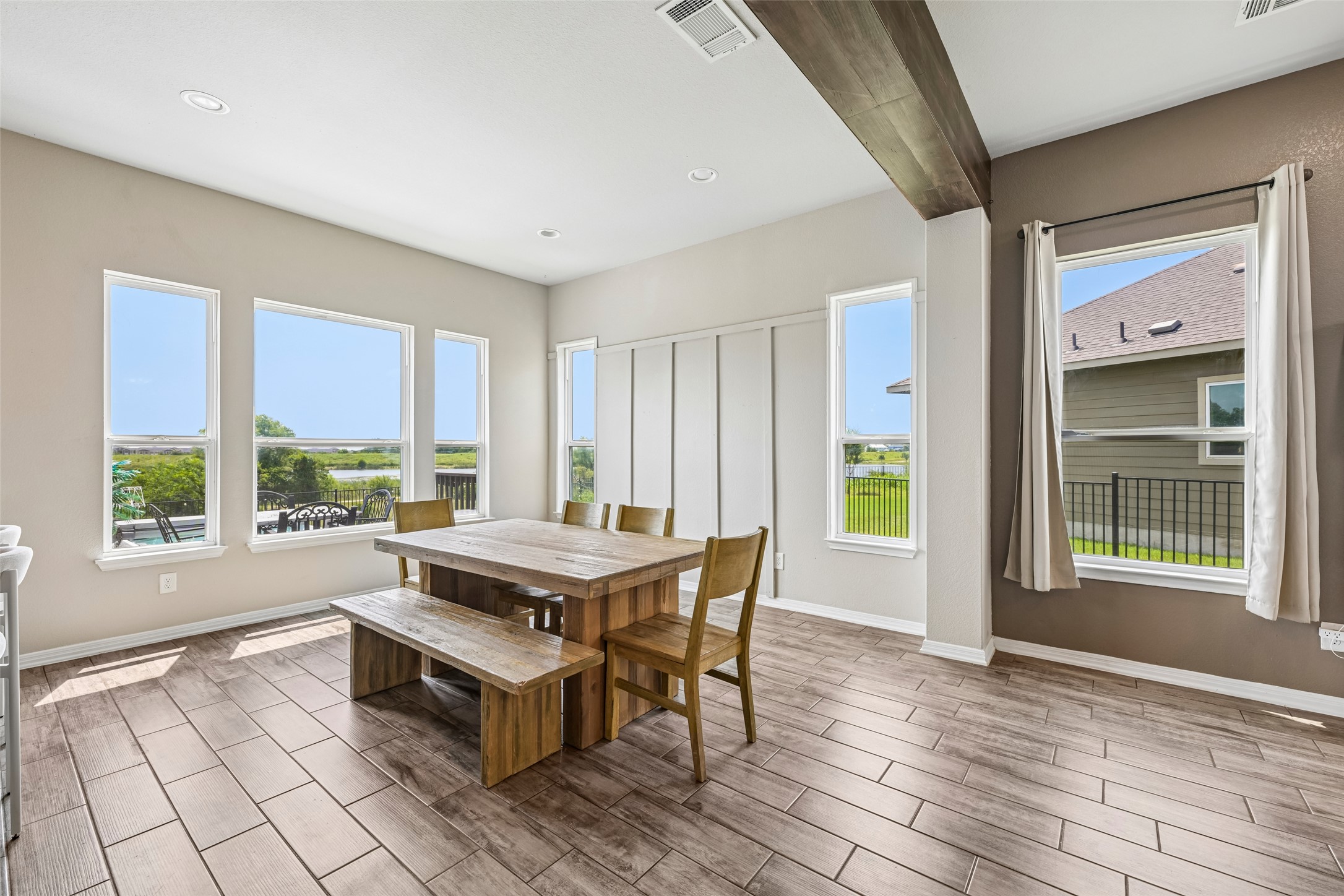 1297 Harwell Loop Kyle, TX 78640 - Photo 12 of 39 Natural light floods this dining area through abundant windows, showcasing the plank-style flooring.