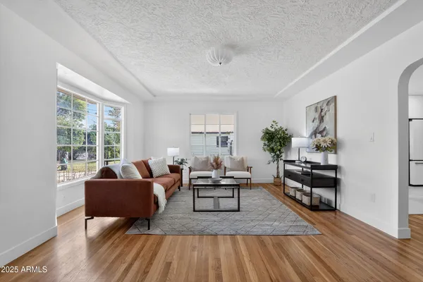 a living room with furniture and a wooden floor