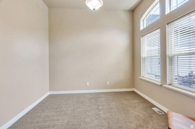 373 East Alexander Drive Elk Ridge, UT 84651 - Photo 13 of 69 Vaulted ceiling, arched transom windows, two large windows with blinds, neutral carpet flooring, and light-toned wall paint