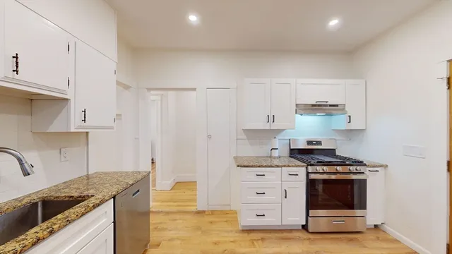a kitchen with granite countertop a stove and a sink