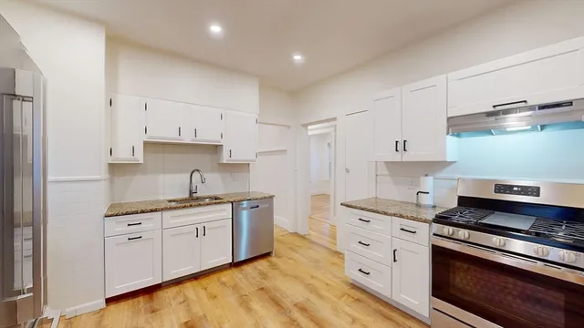 a kitchen with stainless steel appliances granite countertop a sink and cabinets