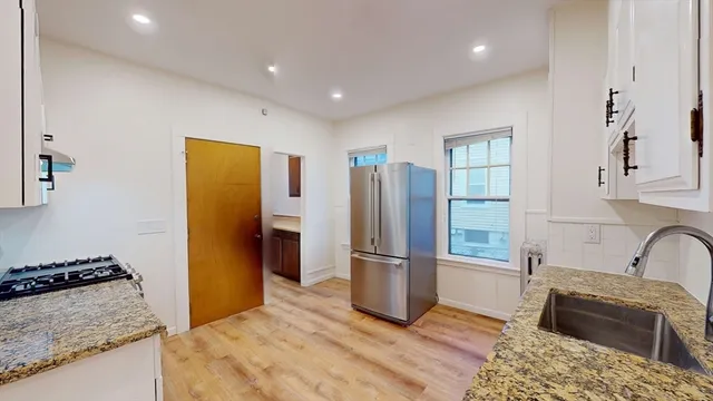 a kitchen with stainless steel appliances granite countertop a refrigerator and a stove top oven
