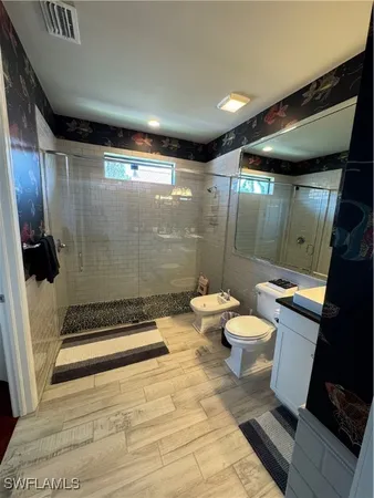a bathroom with a toilet and a shower
