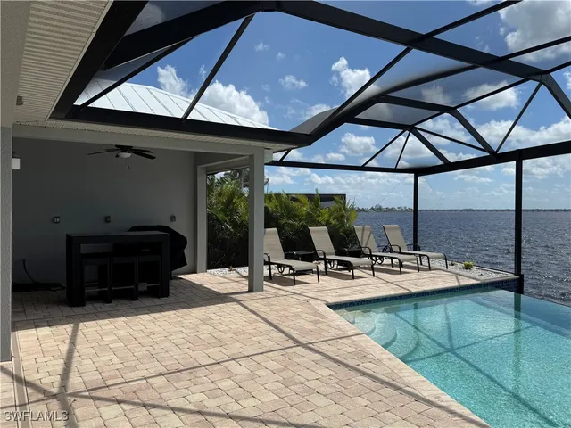 a view of a patio with a table and chairs under an umbrella