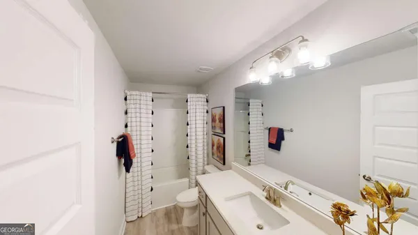 a bathroom with a sink mirror and shower